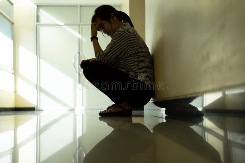 Mulher triste sentada sozinha em uma sala vazia