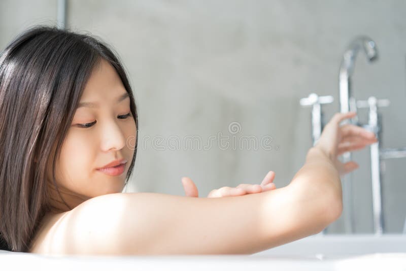 Mulher asi?tica nova que relaxa em um banho Conceito f?mea do skincare imagens de stock royalty free Mulher asi?tica nova que relaxa em um banho Conceito f?mea do skincare imagens de stock royalty free