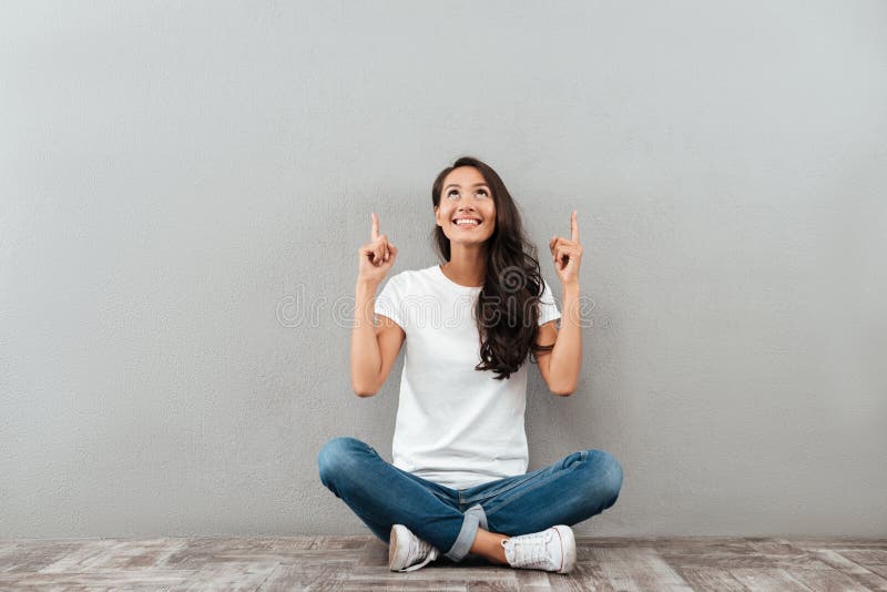 Mulher asiática alegre feliz que senta-se no assoalho fotos de stock Mulher asiática alegre feliz que senta-se no assoalho fotos de stock