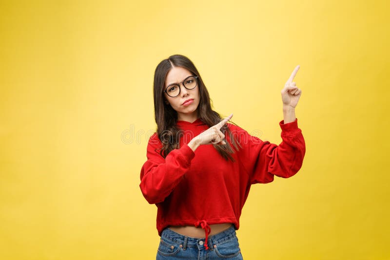 Mulher asiática bonita nova que aponta ao copyspace, no fundo amarelo foto de stock Mulher asiática bonita nova que aponta ao copyspace, no fundo amarelo foto de stock