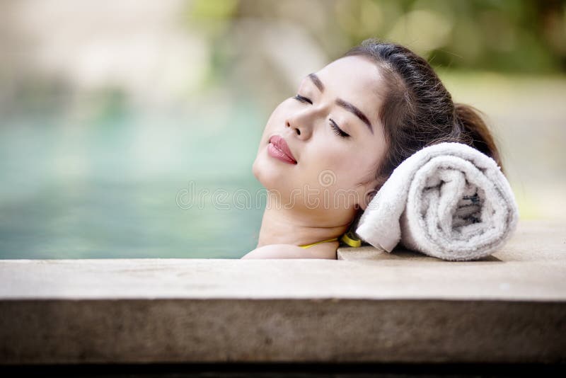 Mulher asiática bonita que encontra-se na piscina imagem de stock Mulher asiática bonita que encontra-se na piscina imagem de stock