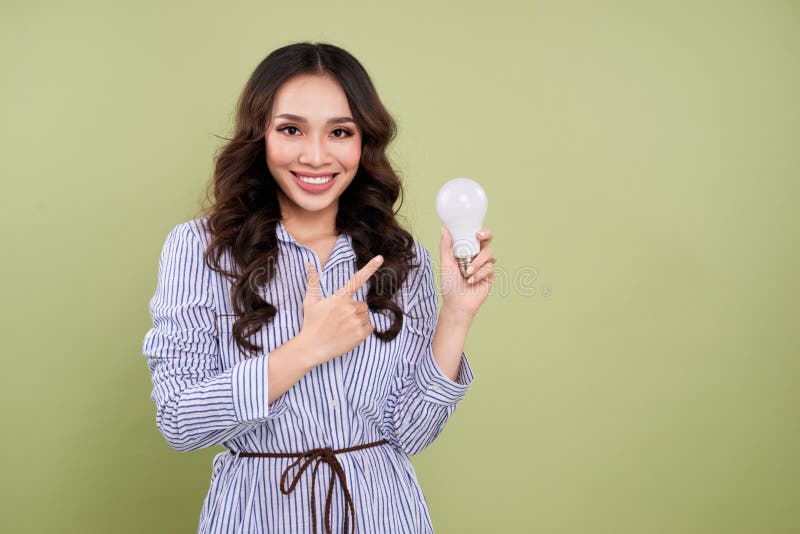 Mulher asiática bonita que guarda e que aponta a ampola fotos de stock Mulher asiática bonita que guarda e que aponta a ampola fotos de stock
