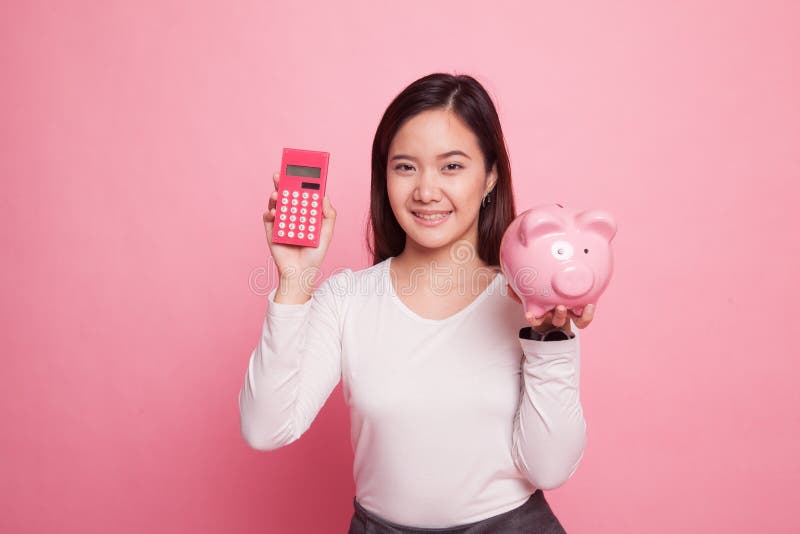 Mulher asiática com calculadora e mealheiro imagens de stock royalty free