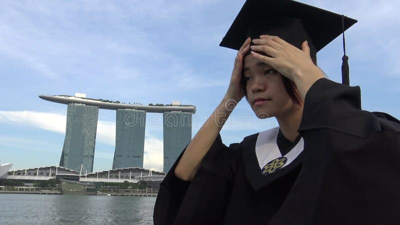 Mulher asiática de 4k colocou a tampa de graduação na frente d'água de singapura