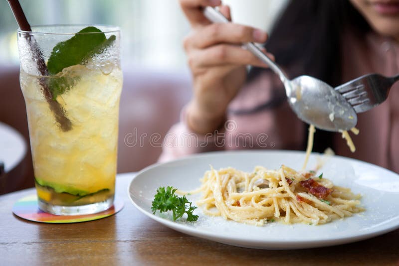 Mulher asiática de sorriso feliz que come a massa italiana com limonada nos restaurantes Fim acima imagens de stock royalty free Mulher asiática de sorriso feliz que come a massa italiana com limonada nos restaurantes Fim acima imagens de stock royalty free