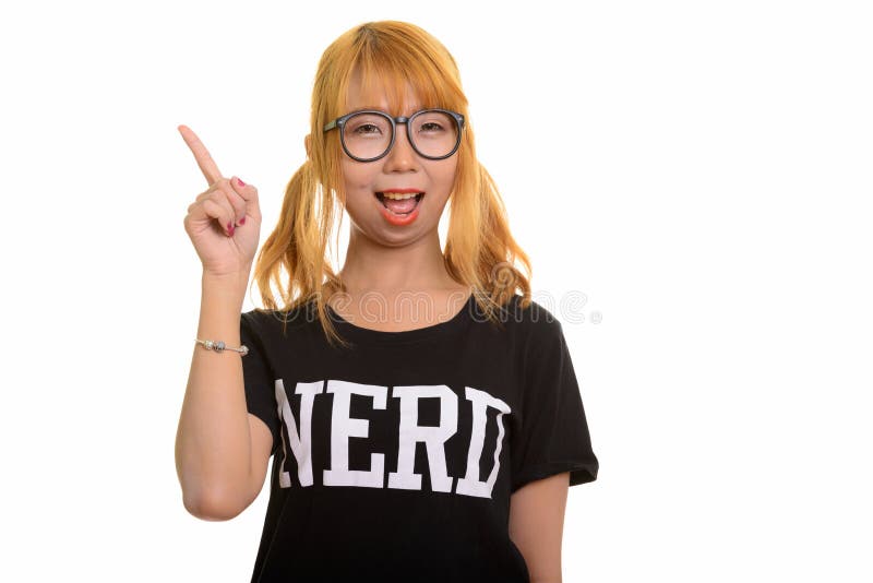 Mulher asiática feliz nova do lerdo que sorri e que aponta o dedo acima imagem de stock Mulher asiática feliz nova do lerdo que sorri e que aponta o dedo acima imagem de stock