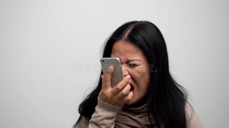 Mulher asiática irritada que grita em seu telefone