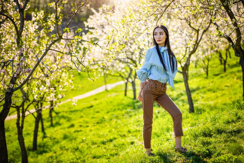 Mulher asiática nova bonita no jardim de florescência das flores da maçã imagens de stock Mulher asiática nova bonita no jardim de florescência das flores da maçã imagens de stock
