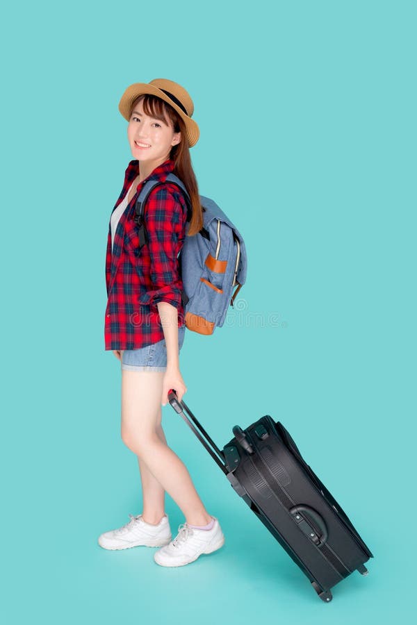 Mulher asiática nova bonita que puxa a mala de viagem isolada no fundo azul, menina de Ásia que tem expressivo imagens de stock royalty free Mulher asiática nova bonita que puxa a mala de viagem isolada no fundo azul, menina de Ásia que tem expressivo imagens de stock royalty free