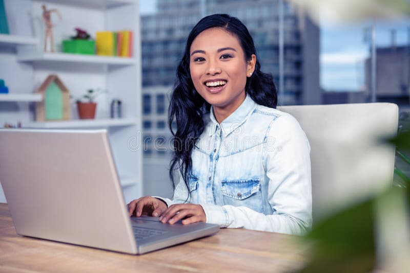 Mulher asiática que usa o portátil imagem de stock Mulher asiática que usa o portátil imagem de stock