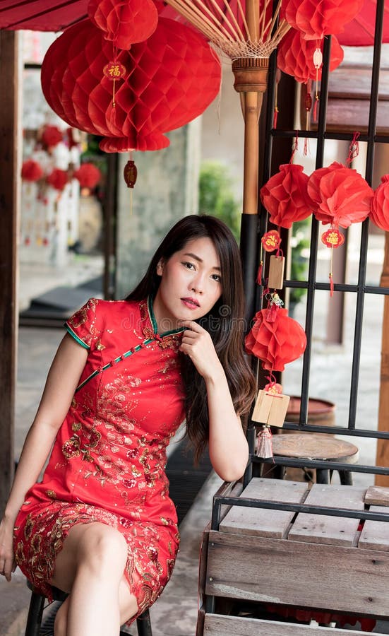 Mulher asiática que veste o vestido tradicional vermelho no festival chinês do ano novo fotografia de stock Mulher asiática que veste o vestido tradicional vermelho no festival chinês do ano novo fotografia de stock