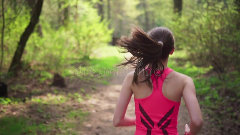 Mulher ativa que corre na floresta ensolarada da mola filme Mulher ativa que corre na floresta ensolarada da mola filme