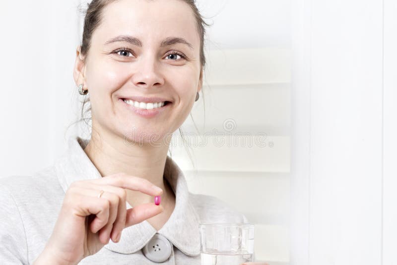 A mulher atrativa nova realiza em seus comprimido da mão e vidro de limpo imagem de stock royalty free A mulher atrativa nova realiza em seus comprimido da mão e vidro de limpo imagem de stock royalty free