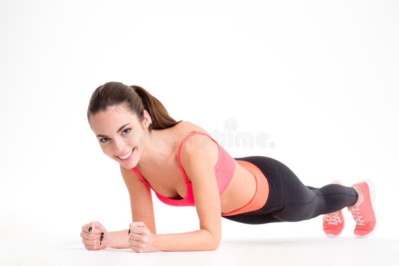 Mulher bonita alegre da aptidão que faz o exercício da prancha imagem de stock Mulher bonita alegre da aptidão que faz o exercício da prancha imagem de stock