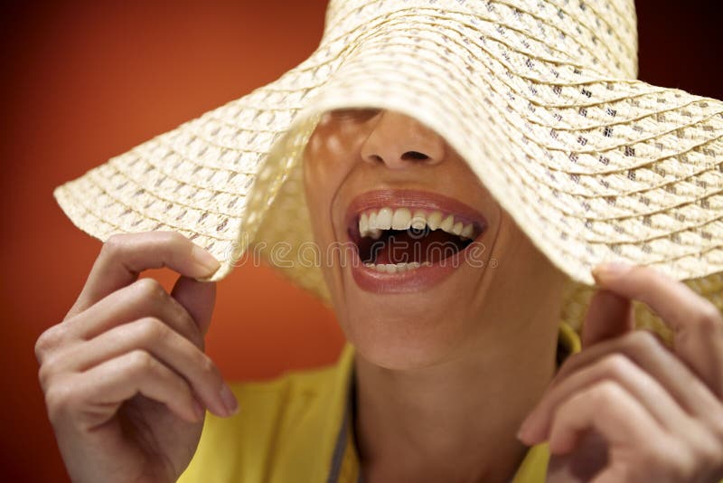 Mulher bonita com chapéu de palha que sorri e que tem o divertimento imagens de stock Mulher bonita com chapéu de palha que sorri e que tem o divertimento imagens de stock