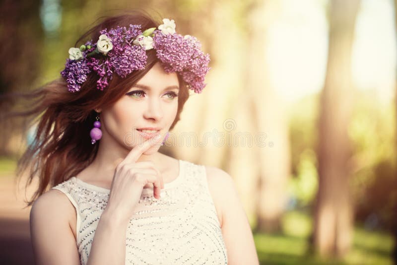 Mulher bonita com flores fora As flores lilás envolvem-se, luz ensolarada imagem de stock royalty free Mulher bonita com flores fora As flores lilás envolvem-se, luz ensolarada imagem de stock royalty free