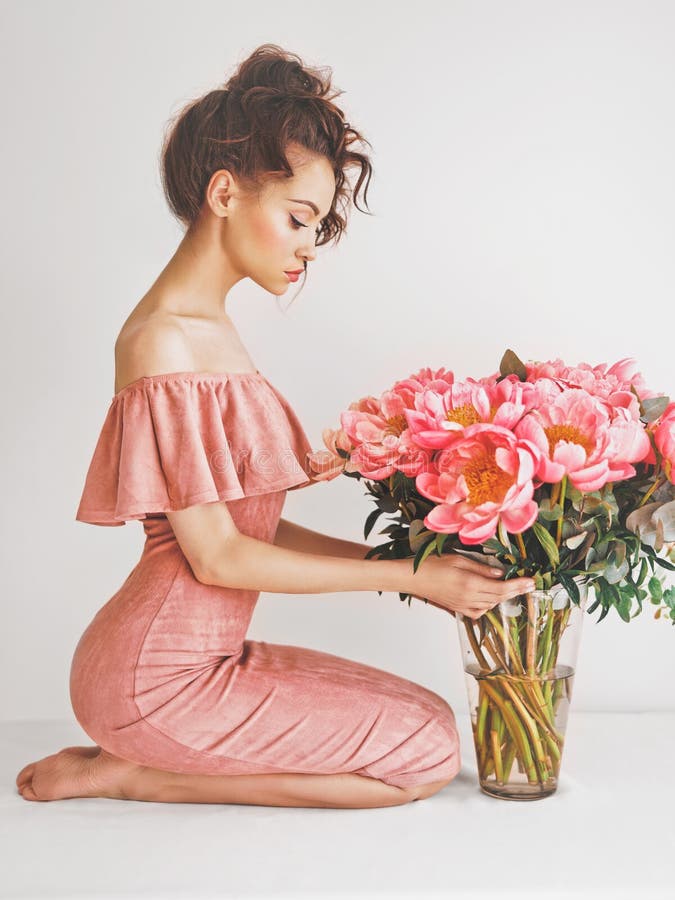 Lifestyle photo of beautiful young woman with pink peonies. Bouquet as gift. Emotions of happiness and joy. Valentines day. Mothers day. Lifestyle photo of beautiful young woman with pink peonies. Bouquet as gift. Emotions of happiness and joy. Valentines day. Mothers day