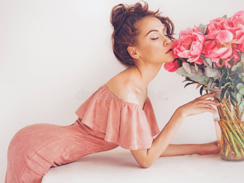 Lifestyle photo of beautiful young woman with pink peonies. Bouquet as gift. Emotions of happiness and joy. Valentines day. Mothers day. Lifestyle photo of beautiful young woman with pink peonies. Bouquet as gift. Emotions of happiness and joy. Valentines day. Mothers day