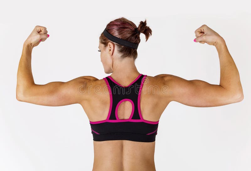A mulher bonita forte da aptidão que dobra seu braço muscles imagem de stock