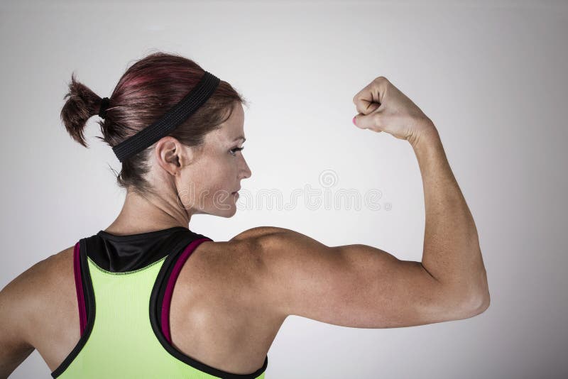 Mulher bonita forte da aptidão que dobra seus braço e músculos traseiros fotografia de stock