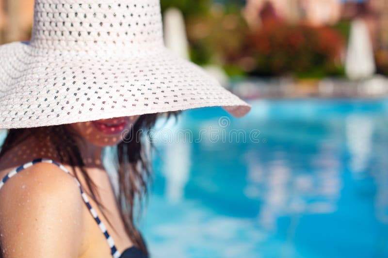 Mulher bonita no chapéu grande branco perto da associação em um dia ensolarado fotografia de stock royalty free Mulher bonita no chapéu grande branco perto da associação em um dia ensolarado fotografia de stock royalty free