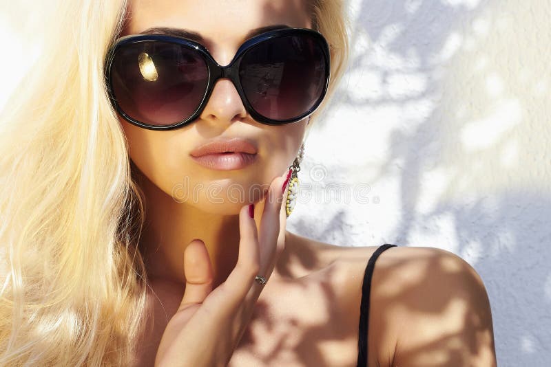 Mulher bonita nos óculos de sol menina loura da beleza dentro perto da parede verão imagens de stock royalty free Mulher bonita nos óculos de sol menina loura da beleza dentro perto da parede verão imagens de stock royalty free