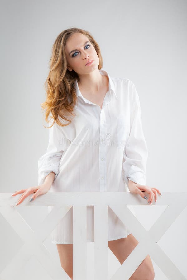Mulher bonita nova em uma camisa de homens brancos imagem de stock Mulher bonita nova em uma camisa de homens brancos imagem de stock