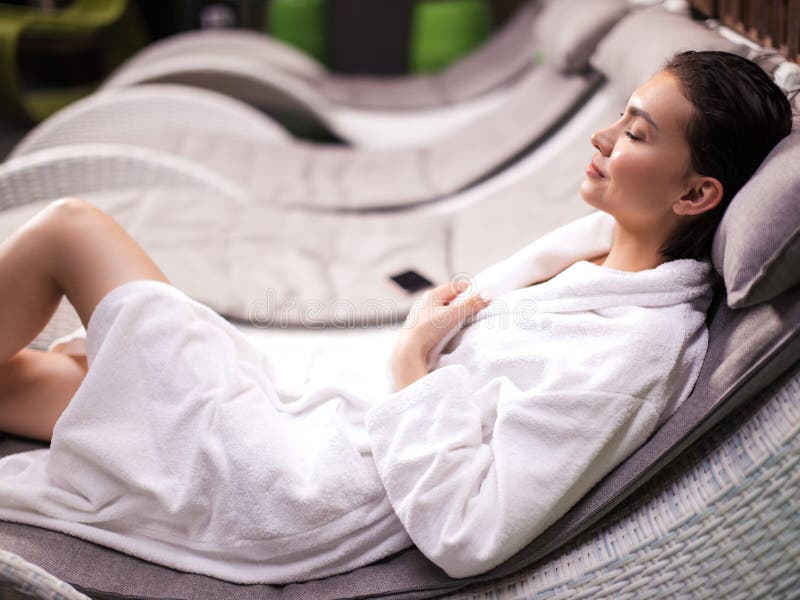 Mulher bonita nova que encontra-se na cama com olhos fechados e que relaxa fotografia de stock Mulher bonita nova que encontra-se na cama com olhos fechados e que relaxa fotografia de stock