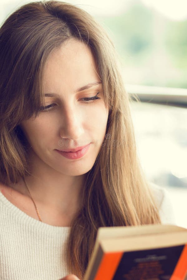 Mulher bonita nova que lê um livro imagens de stock Mulher bonita nova que lê um livro imagens de stock