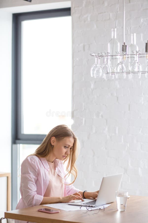Mulher bonita nova que surfa a rede em casa foto de stock Mulher bonita nova que surfa a rede em casa foto de stock