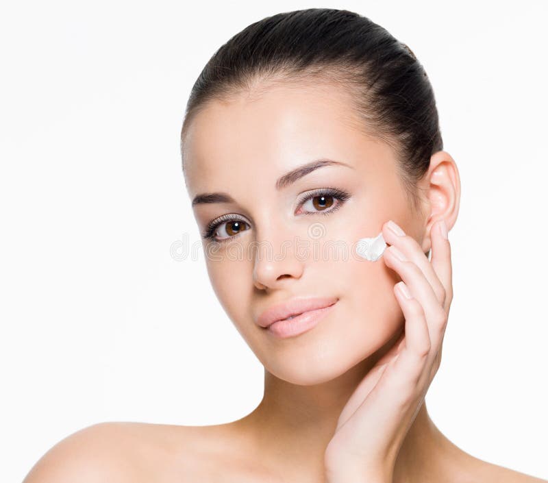 Mulher bonita que aplica o creme na face imagens de stock Mulher bonita que aplica o creme na face imagens de stock