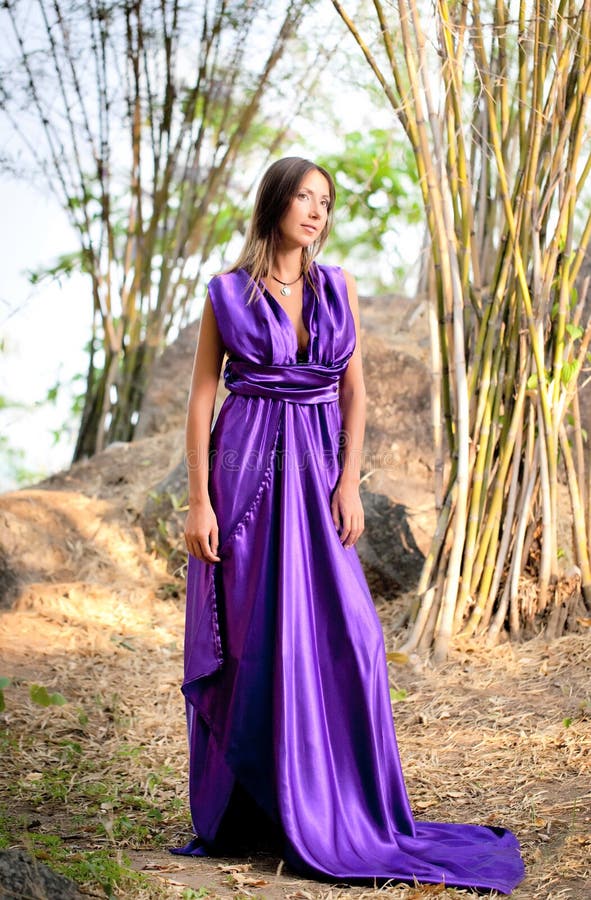 Mulher bonita que desgasta um vestido roxo longo foto de stock royalty free Mulher bonita que desgasta um vestido roxo longo foto de stock royalty free