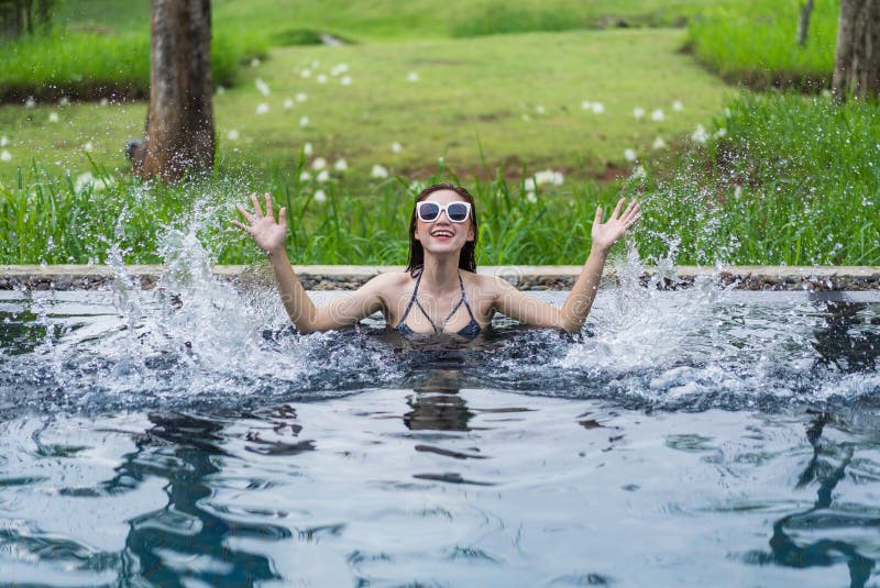 Mulher bonita que espirra a água na piscina fotografia de stock royalty free Mulher bonita que espirra a água na piscina fotografia de stock royalty free