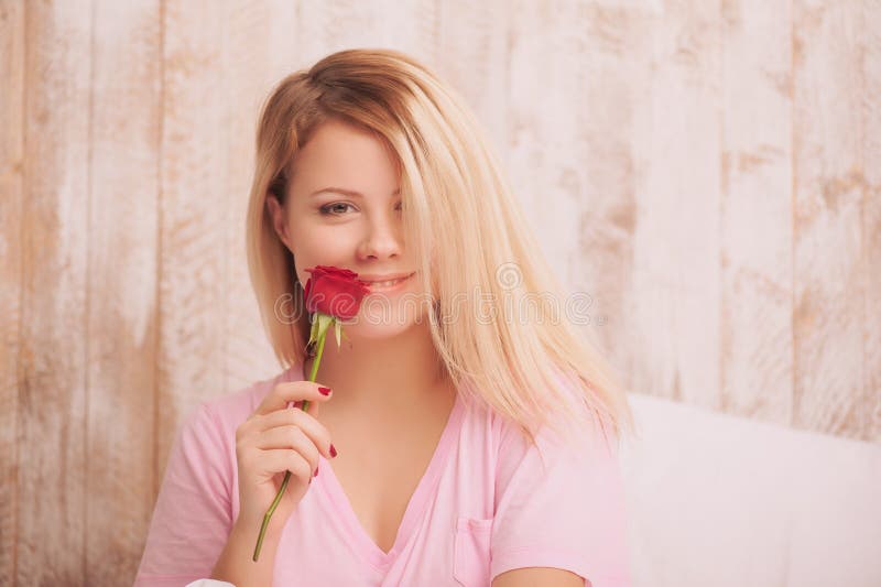 A mulher bonita que prende o vermelho levantou-se imagem de stock A mulher bonita que prende o vermelho levantou-se imagem de stock