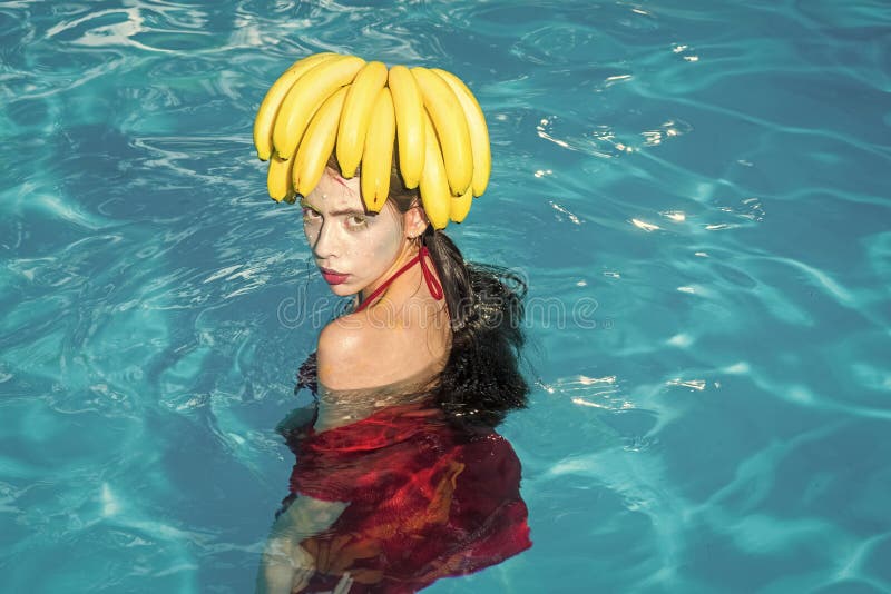 A mulher bonita relaxa na piscina do luxo dos termas mulher bonita com a banana na cabeça fotografia de stock A mulher bonita relaxa na piscina do luxo dos termas mulher bonita com a banana na cabeça fotografia de stock