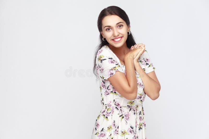 A mulher bonito e da felicidade nas flores veste-se, olhando a câmera e imagem de stock royalty free A mulher bonito e da felicidade nas flores veste-se, olhando a câmera e imagem de stock royalty free