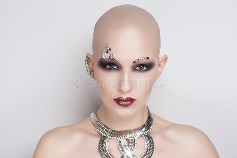 Close up portrait of beautiful bald woman. Perfect beige skin, sexual naked shoulders. passionate girl with informal strange appearance. Challenging society, cut hair. Gray background free place. Close up portrait of beautiful bald woman. Perfect beige skin, sexual naked shoulders. passionate girl with informal strange appearance. Challenging society, cut hair. Gray background free place
