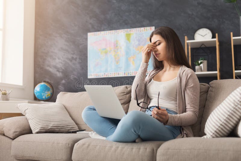 Mulher cansada a trabalhar no portátil em casa fotos de stock