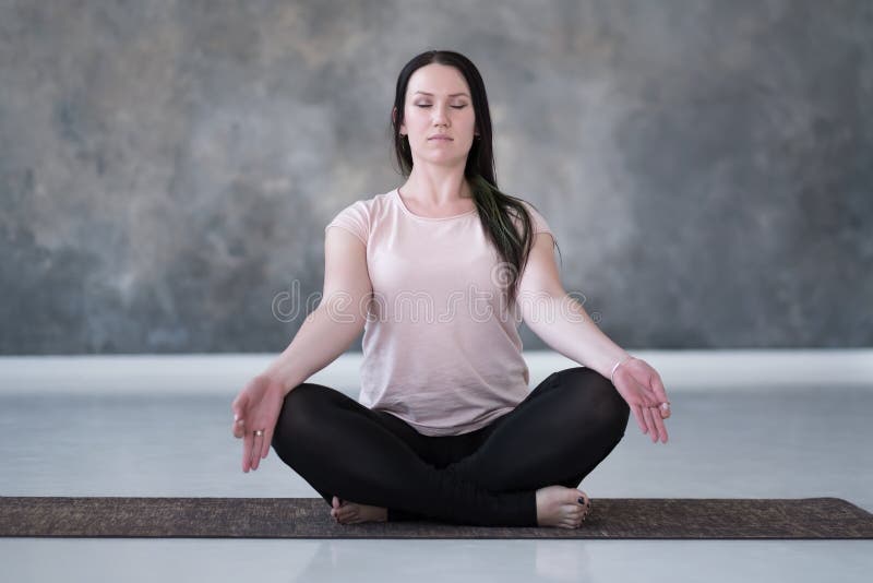 Uma mulher está ajoelhada no chão com o braço dobrado e exercícios de ioga  asana fotos, imagens de © ShotStudio #453397350