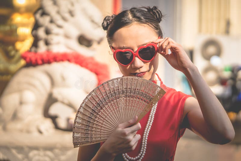 Mulher chinesa com os óculos de sol com o fã de madeira para o conceito chinês moderno da menina imagens de stock royalty free Mulher chinesa com os óculos de sol com o fã de madeira para o conceito chinês moderno da menina imagens de stock royalty free