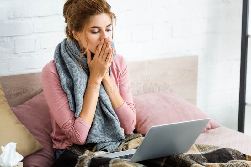 Mulher chocada com cachecol cinza segurando laptop imagens de stock royalty free