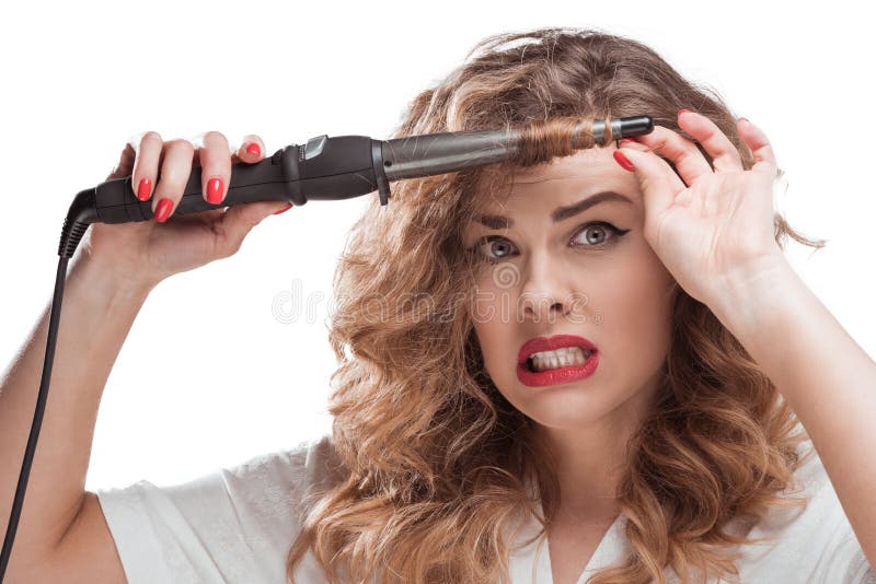 Mulher chocada com um modelador de cabelo nas mãos a olhar para a câmara fotos de stock