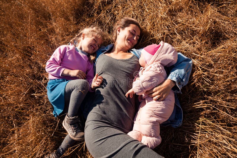 A mulher com bebê e menina aprecia a natureza foto de stock A mulher com bebê e menina aprecia a natureza foto de stock