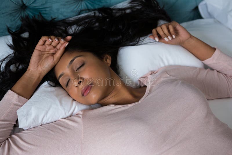 Mulher com cabelo longo que dorme na cama imagem de stock Mulher com cabelo longo que dorme na cama imagem de stock