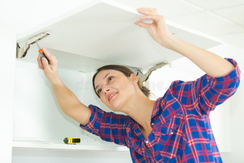 Mulher com mobília automontada na cozinha fotos de stock