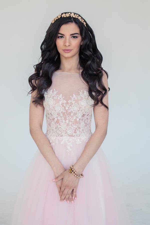 Mulher com o cabelo encaracolado longo que veste o vestido cor-de-rosa imagens de stock Mulher com o cabelo encaracolado longo que veste o vestido cor-de-rosa imagens de stock