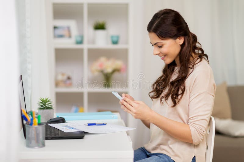 Mulher com os papéis e o smartphone que trabalham em casa imagens de stock Mulher com os papéis e o smartphone que trabalham em casa imagens de stock