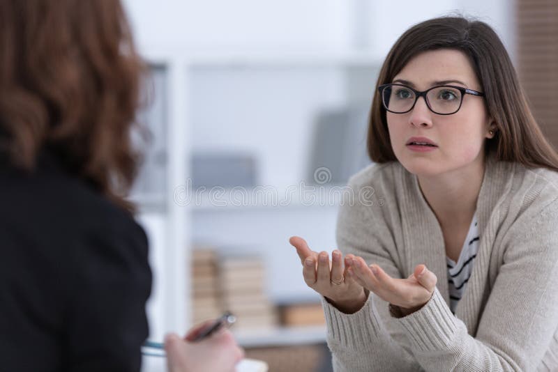 Mulher com problema e conselheiro durante a sessão de terapia fotografia de stock Mulher com problema e conselheiro durante a sessão de terapia fotografia de stock