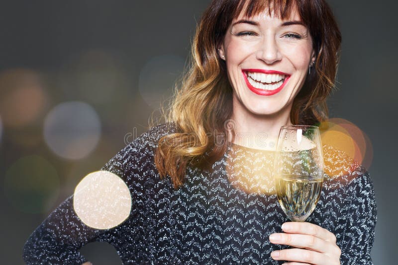 Mulher com um vidro do champanhe no fundo, em alargamentos e no bokeh escuros Senhora com comemoração longa e laughi dos bordos d foto de stock Mulher com um vidro do champanhe no fundo, em alargamentos e no bokeh escuros Senhora com comemoração longa e laughi dos bordos d foto de stock