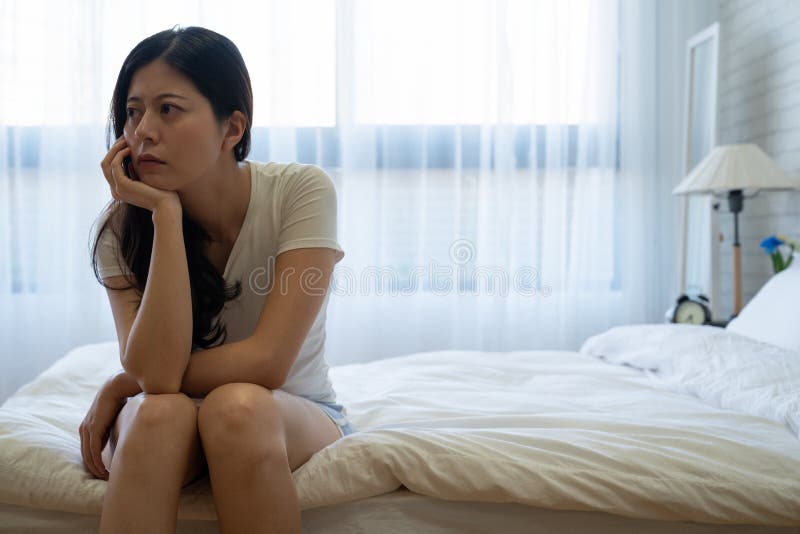 A mulher comprimida na cama considera sobre problemas foto de stock